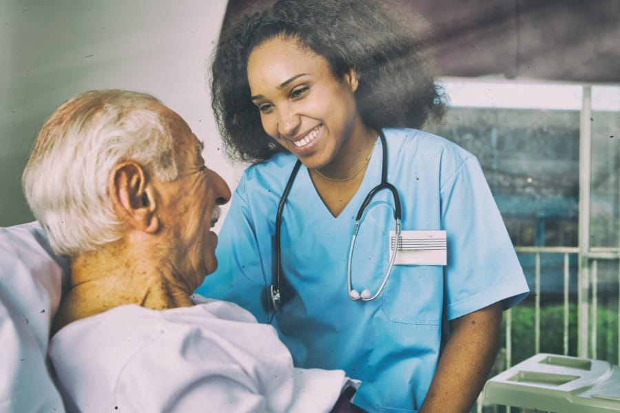 Nurse and her elderly patient smiling