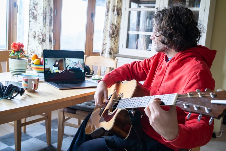 A man learning how to play guitar