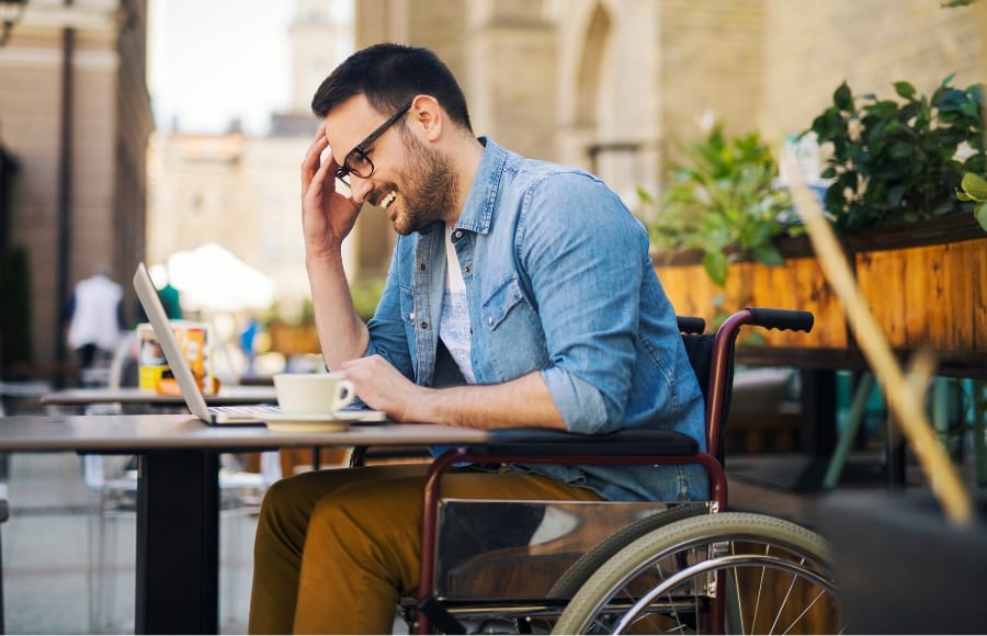 A young adult in a wheelchair smiling