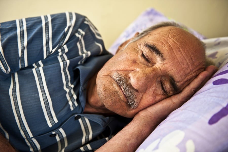 An elderly man sleeping and getting rest