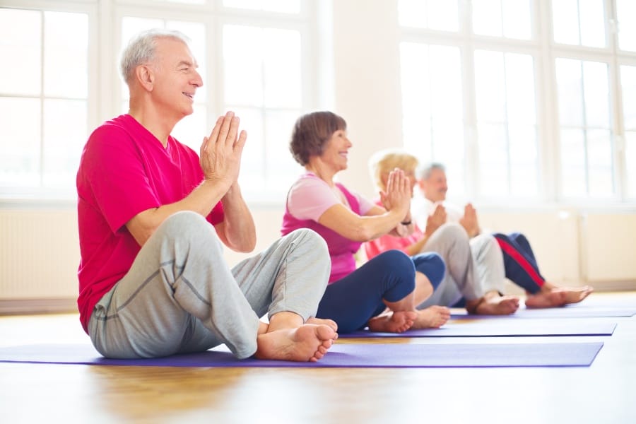 Elderly folks doing yoga to minimize stress