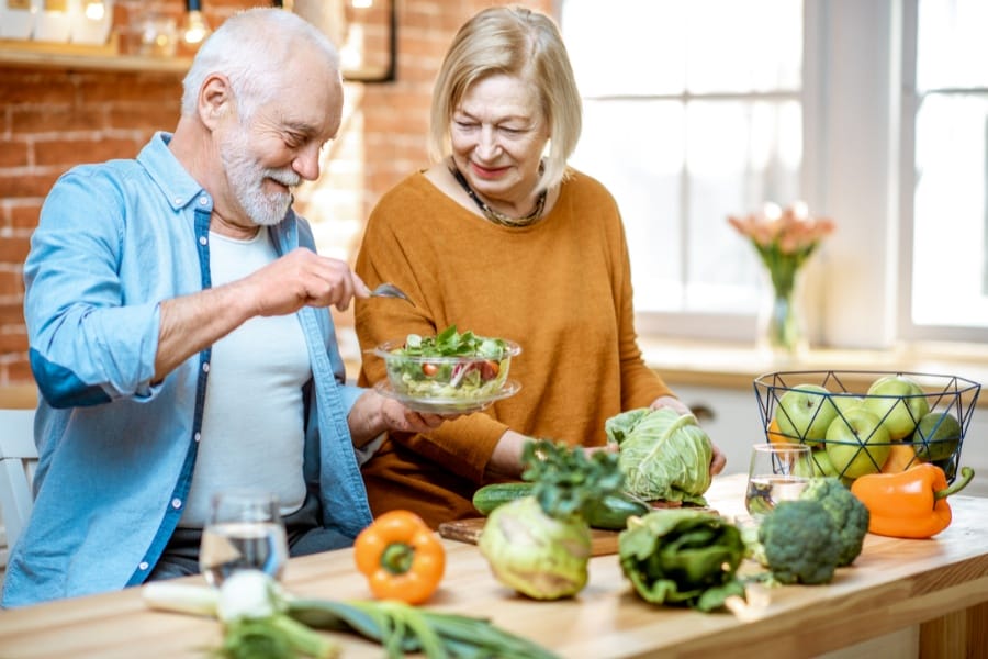 A happy senior couple eating healthy foods