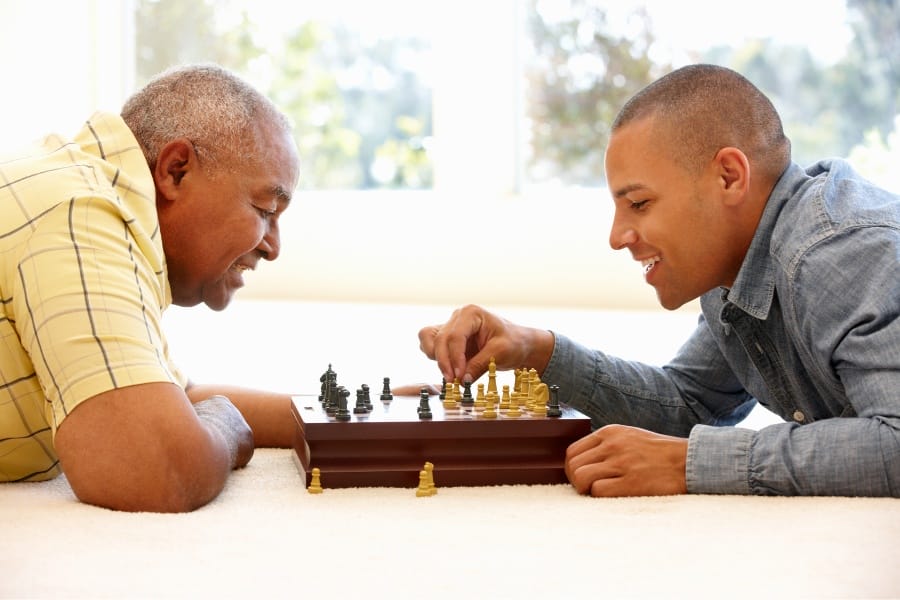 A grandfather and son playing chess