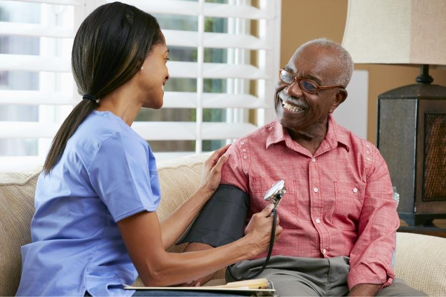 LPN checking her patient's blood pressure at their home in Parkland