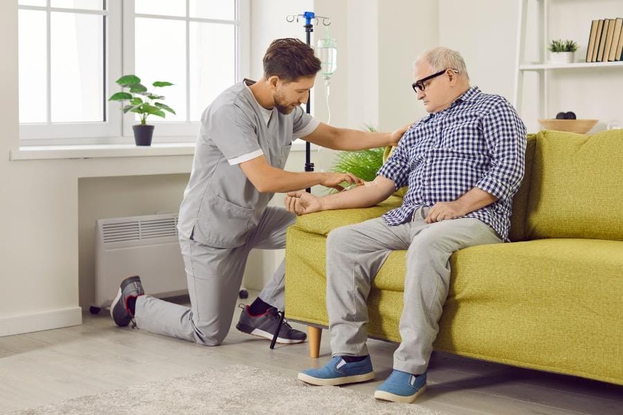 Private nurse doing an infusion for an elderly man