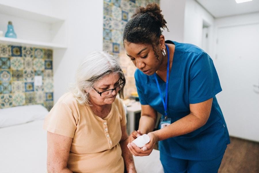 Private nurse helping client with her medication