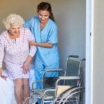 LVN post op nurse helping a patient off the bed