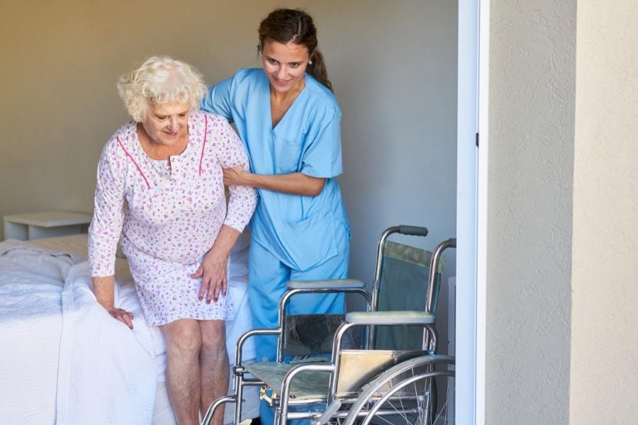 LVN post op nurse helping a patient off the bed