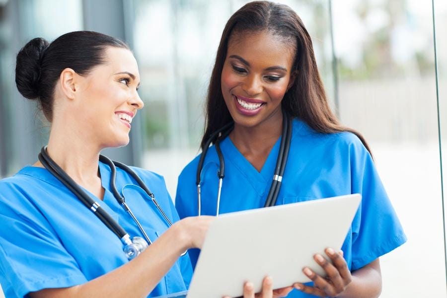 Two RNs smiling at a hospital