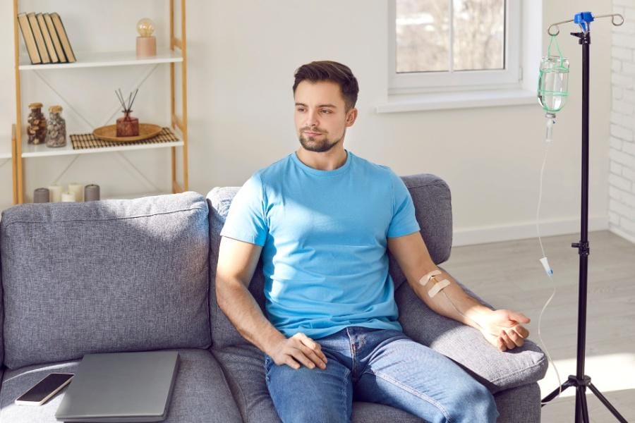 A man receiving an iv infusion in his home