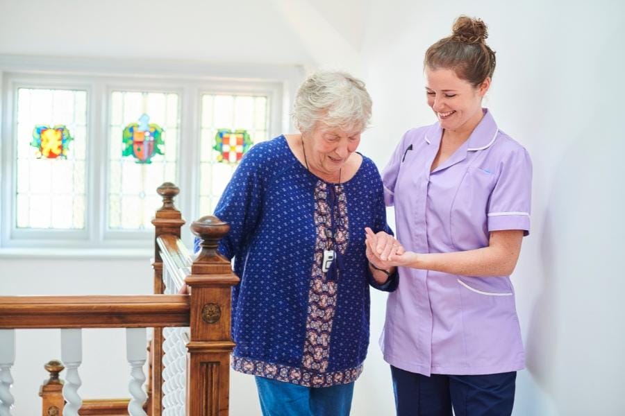 Home nurse helping a patient climb the stairs