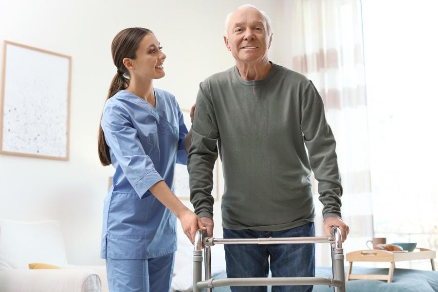 A home nurse with a client using a walker after surgery