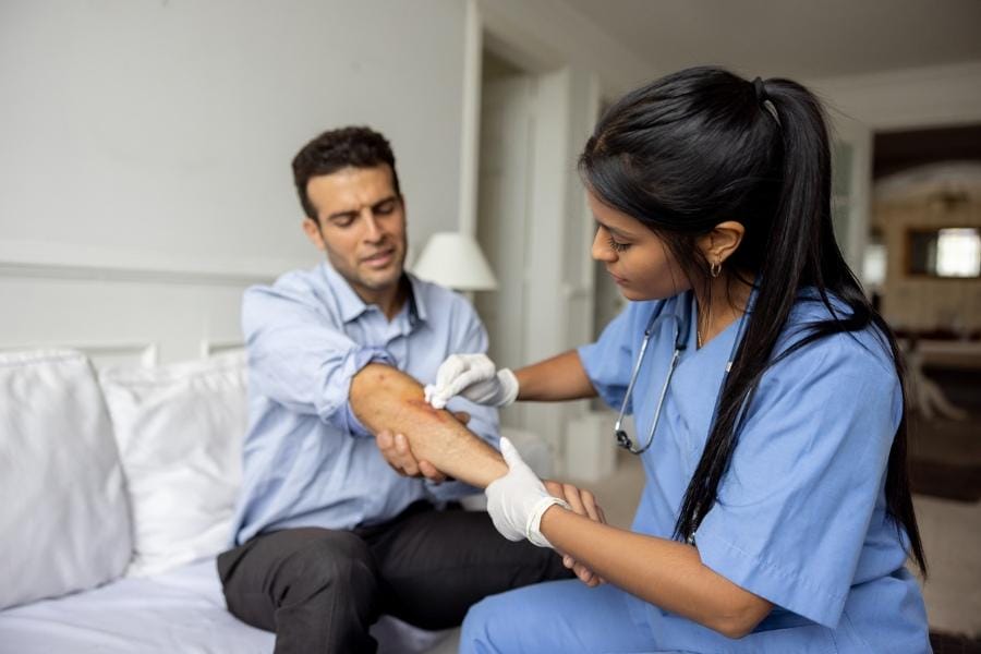 Home nurse treating a wound