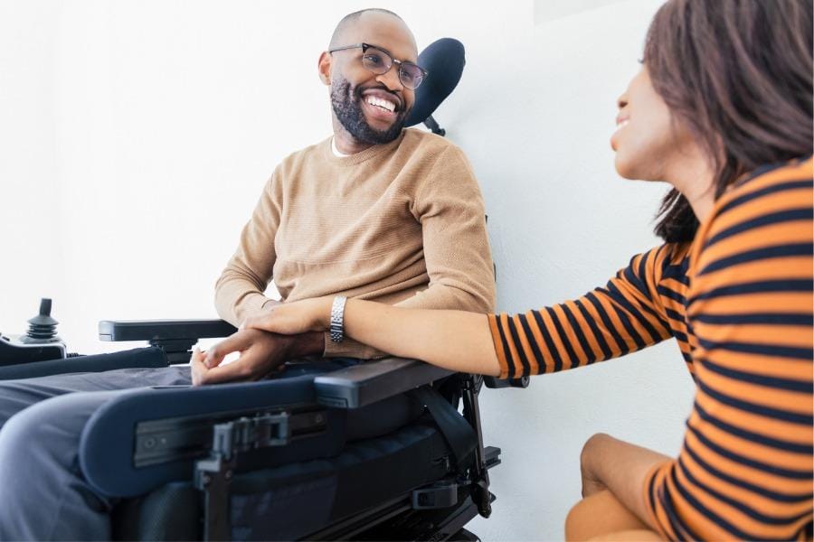 A man smiling in a wheel chair