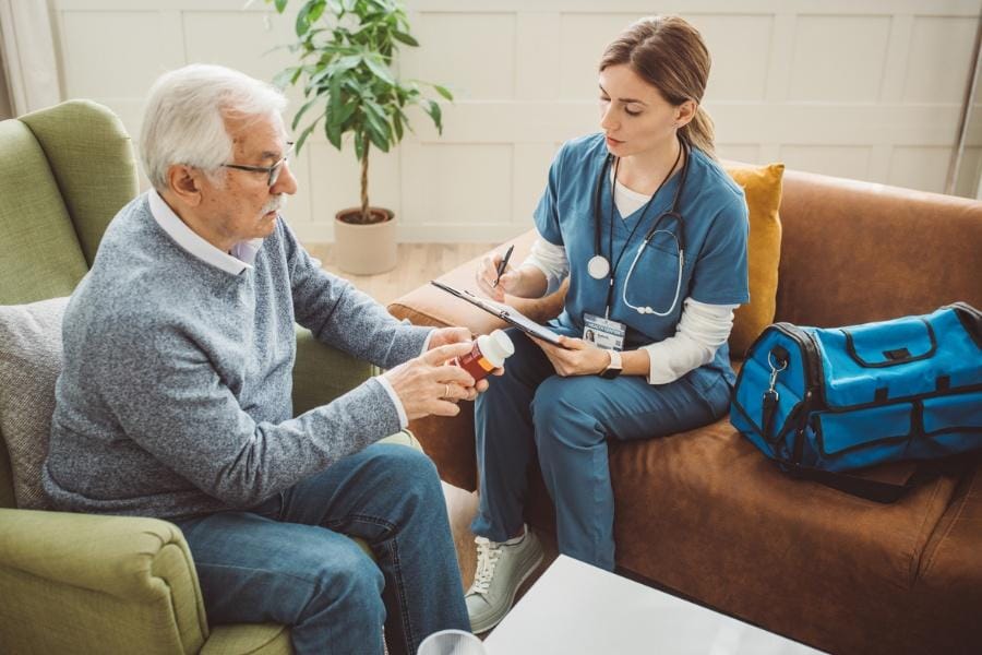 A client receiving pill management from a home nurse