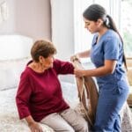 after surgery care nurse assisting her client getting dressed